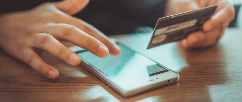 Person using a smartphone and credit card content