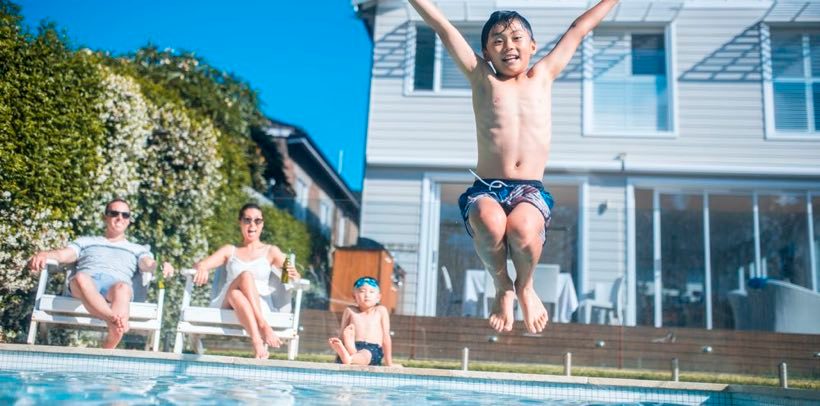 Boy jumping into pool article image content