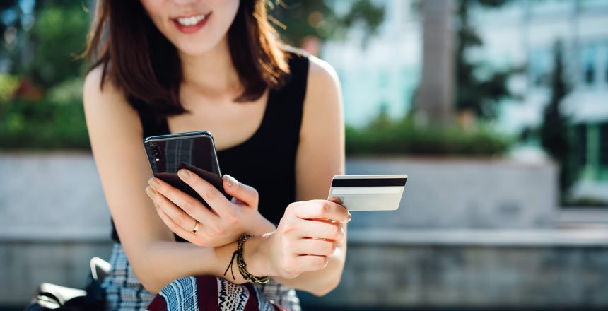Woman holding credit card and phone article image content