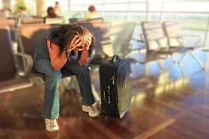 Women depressed by her delayed flight as she has no travel insurance