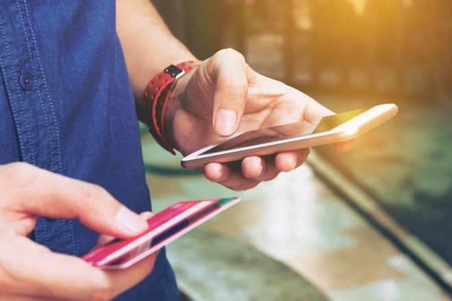 person-using-mobile-phone-and-credit-card