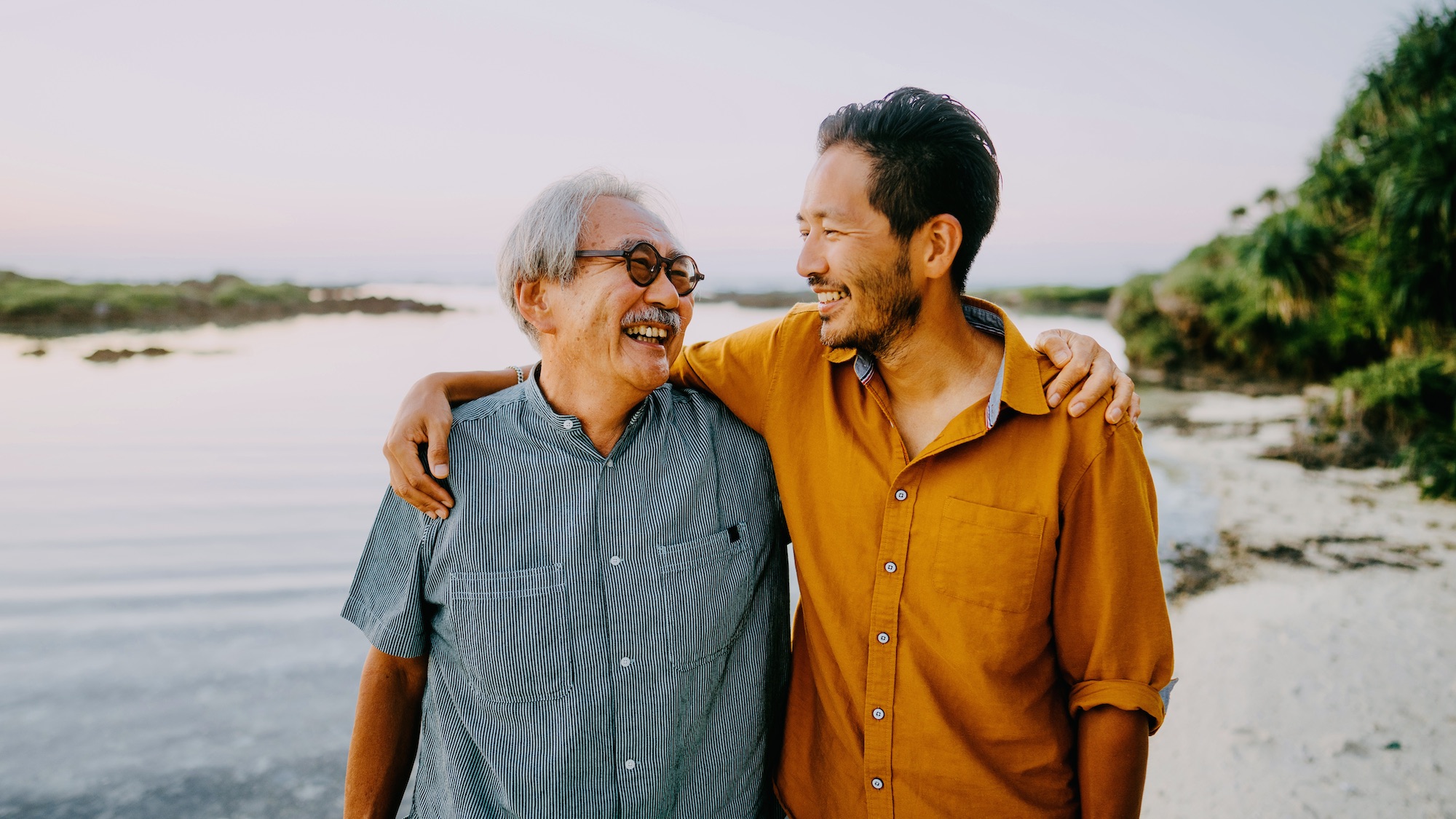 Father and son smiling on the beach