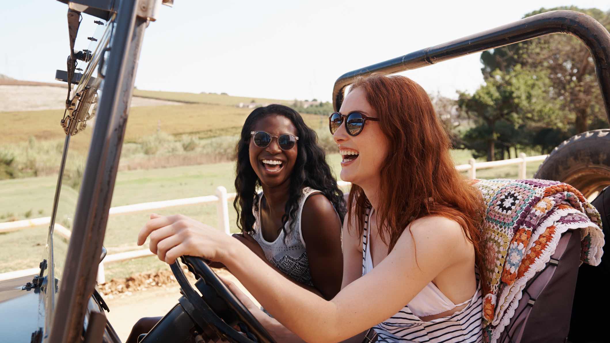People with car insurance driving and laughing