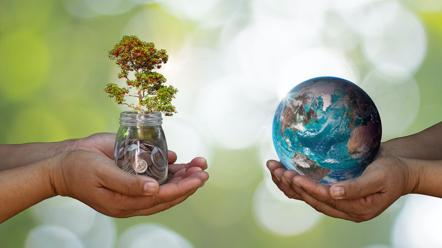 Two pairs of hands, one holding a jar of coins and mini trees, the other holding a globe to symbolise divestment.