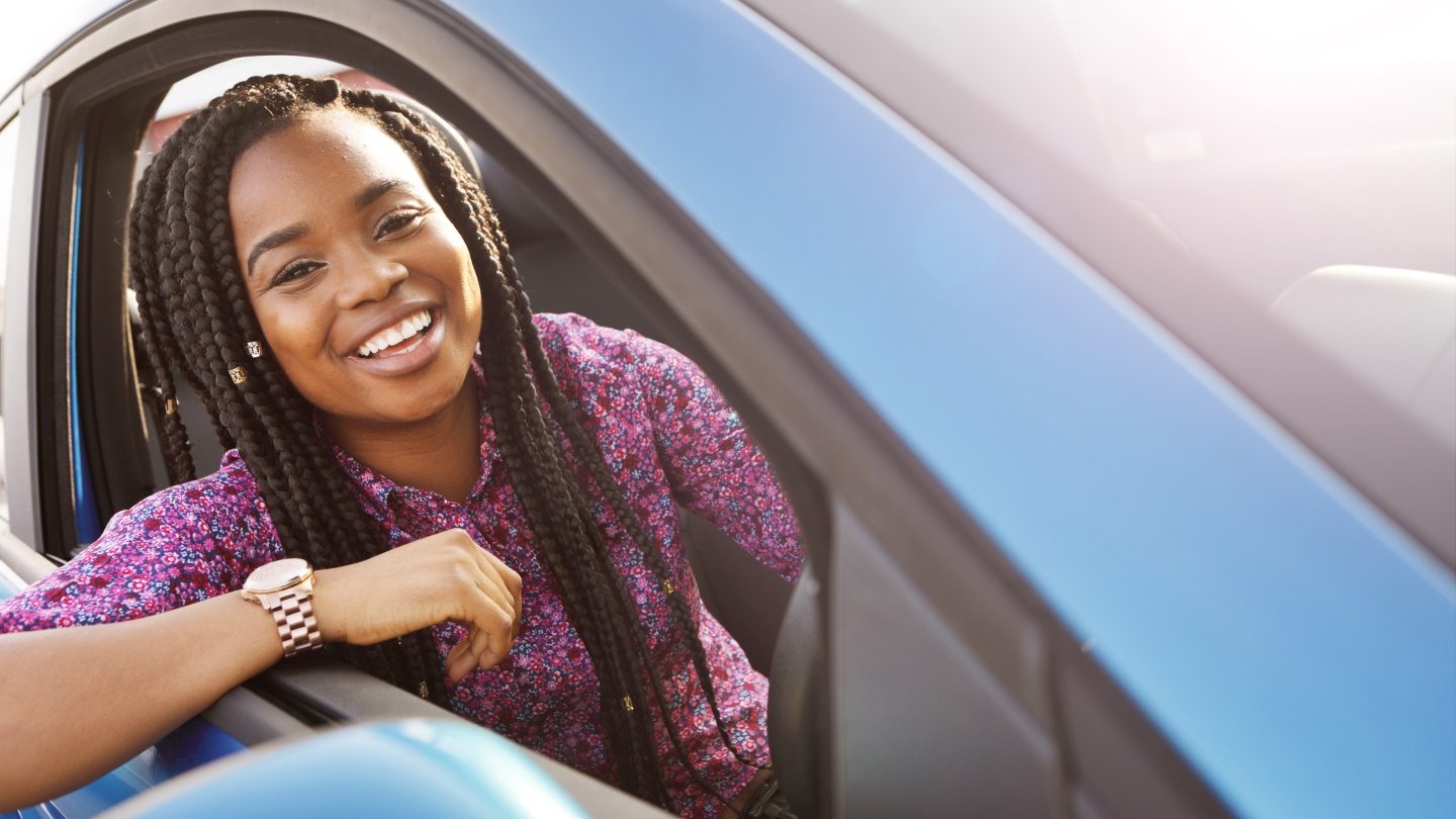 woman smiling in a yellow car knowing best car loans in australia