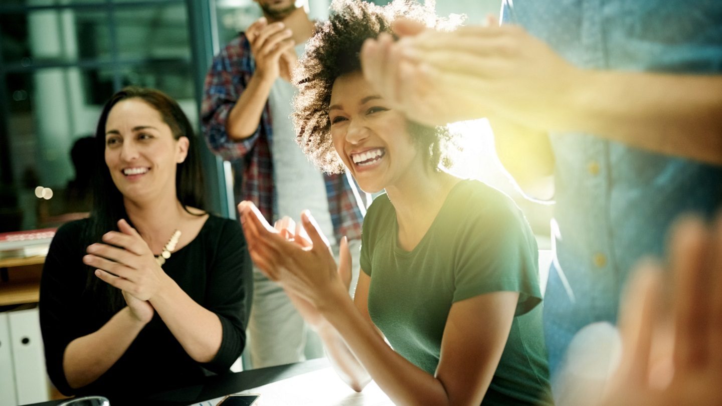 women in a company clapping