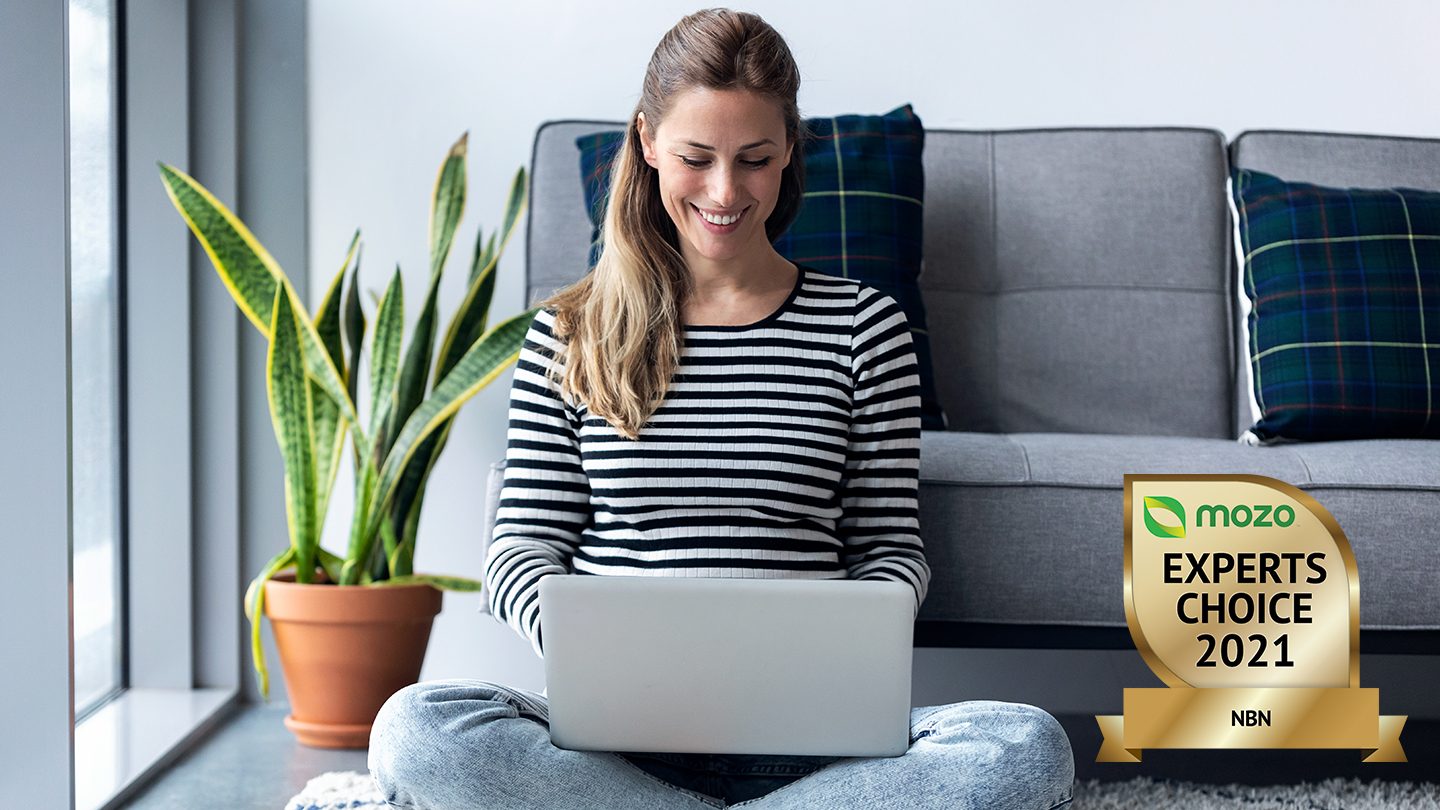 Woman on laptop in living room using Tomi's award-winning NBN plan.