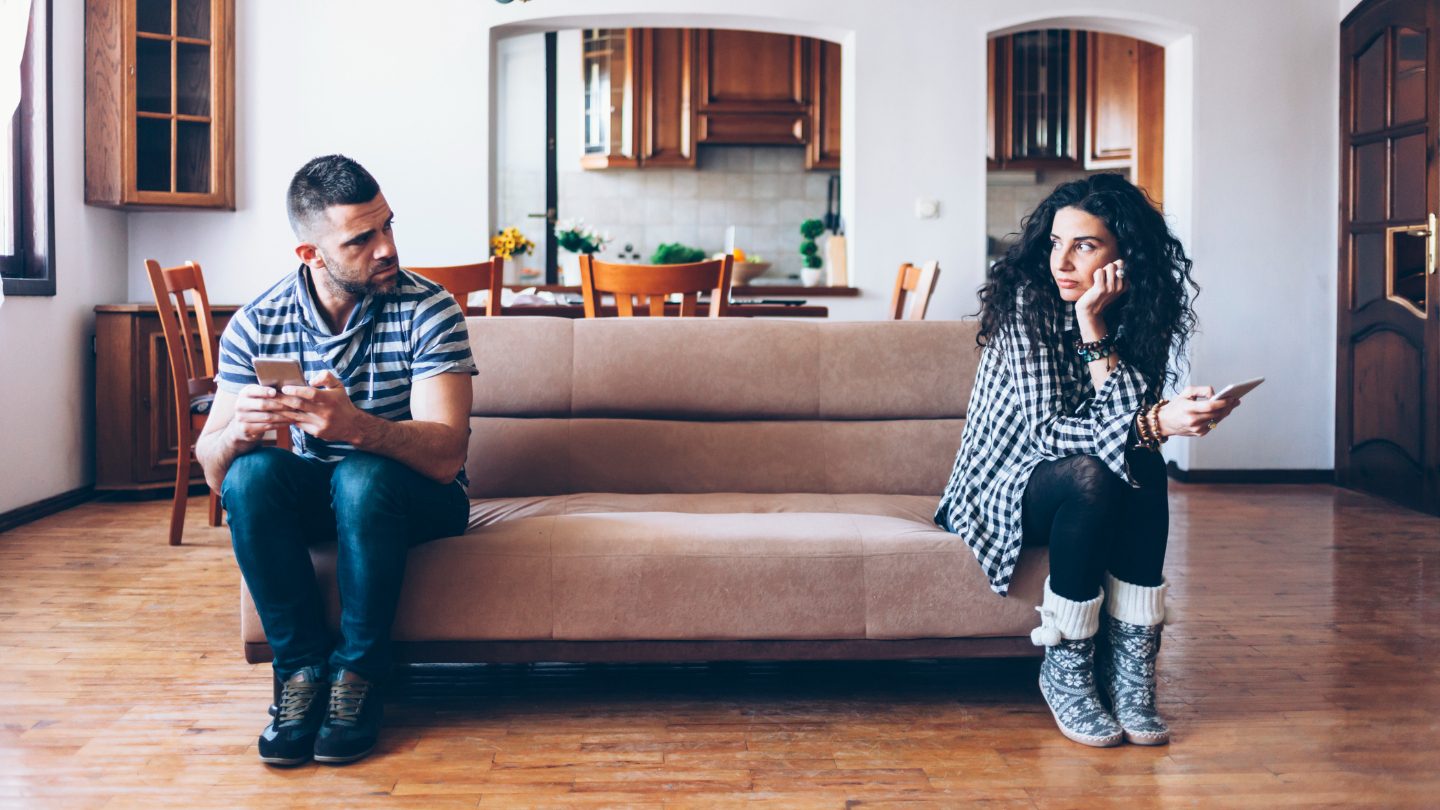 Divorced couple sitting on couch.