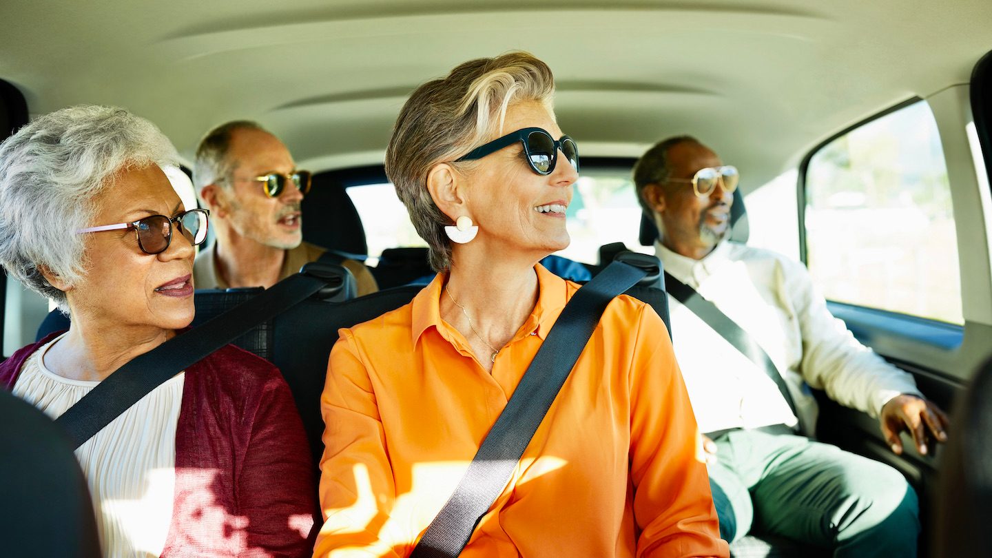 Senior citizens smile in their rideshare.