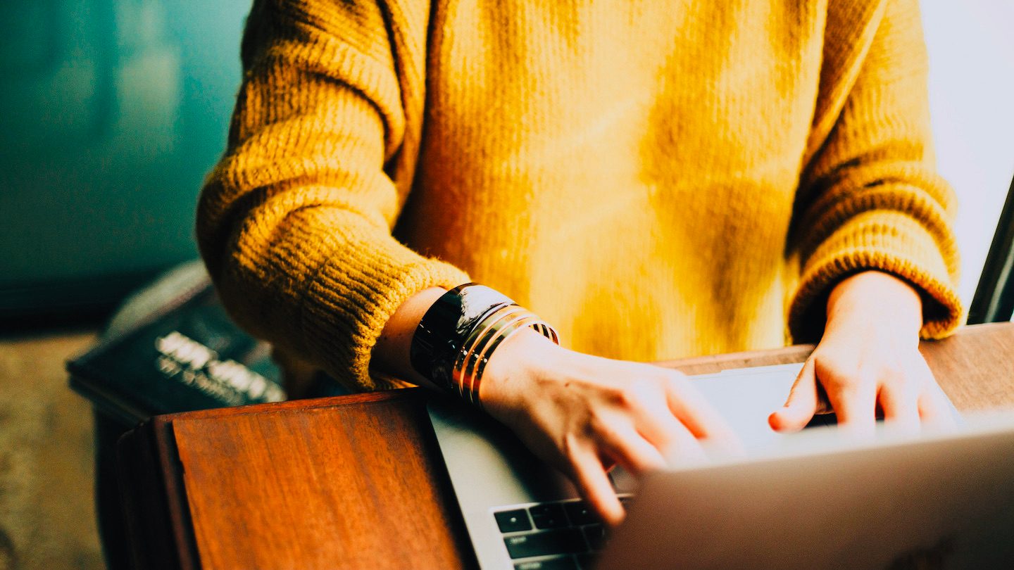 A woman types at her laptop.