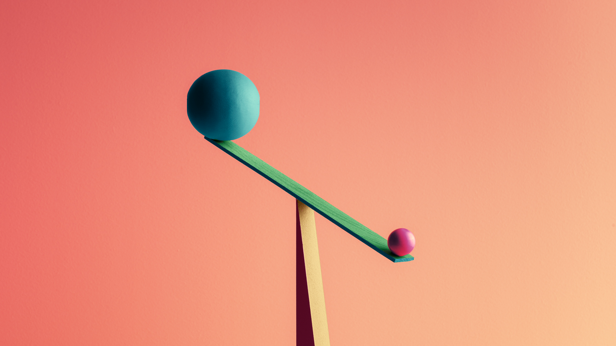 One large ball and one small ball are balanced on a seesaw, representing the balance of debt to your income.
