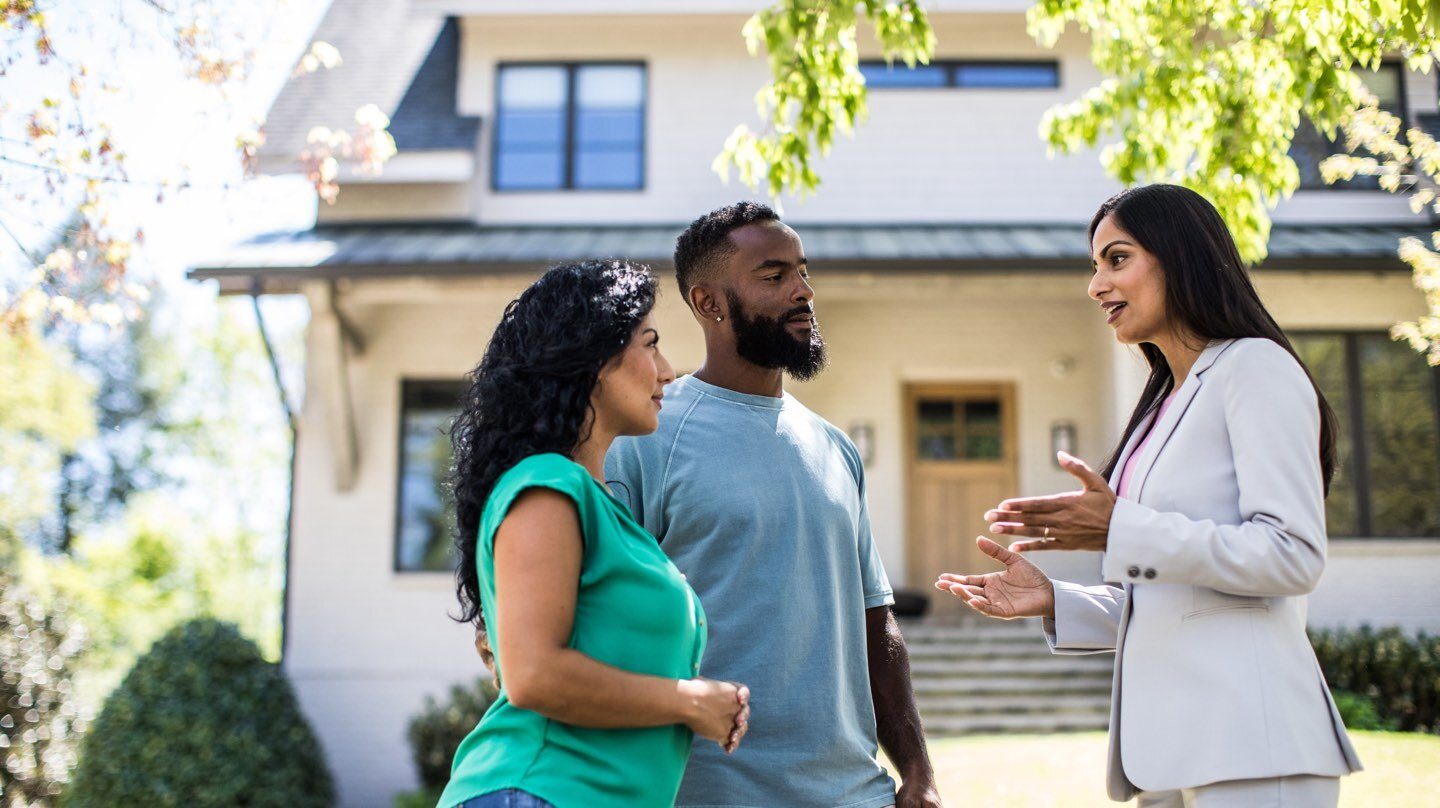 couple talking to a real estate agent about property valuation