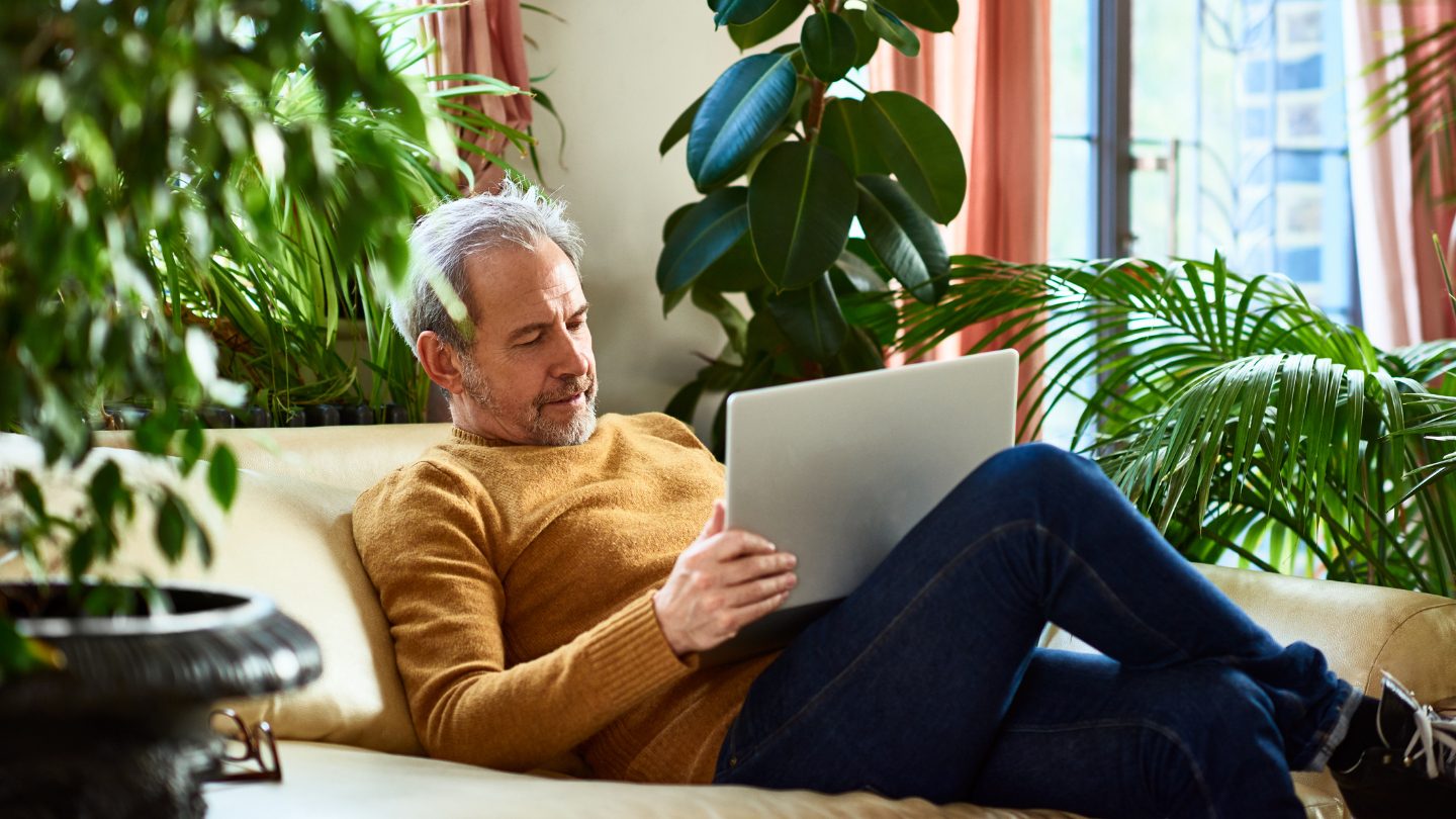 Man on couch using laptop.