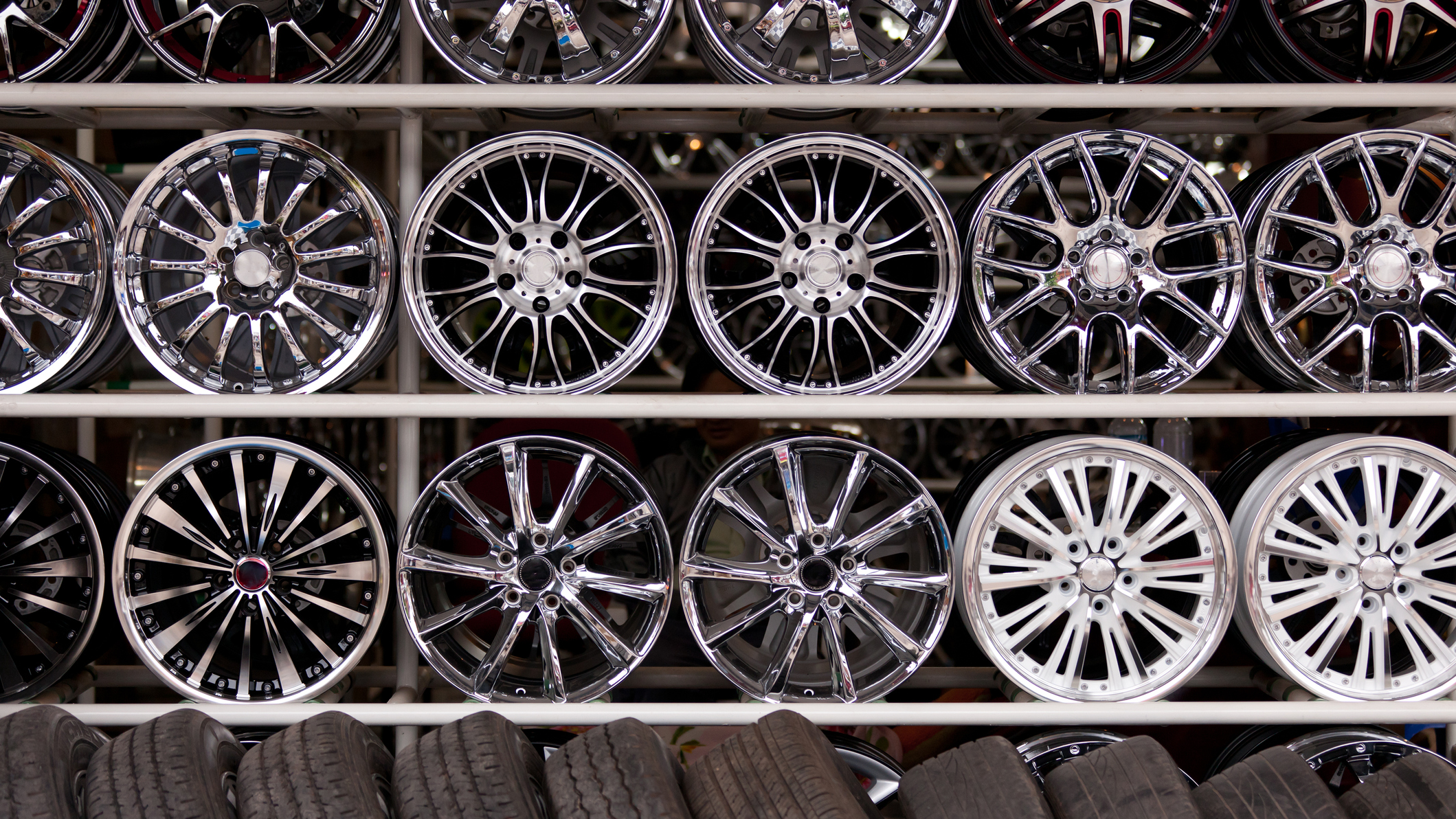 A shelf at an auto shop with a range of different alloy car wheels.