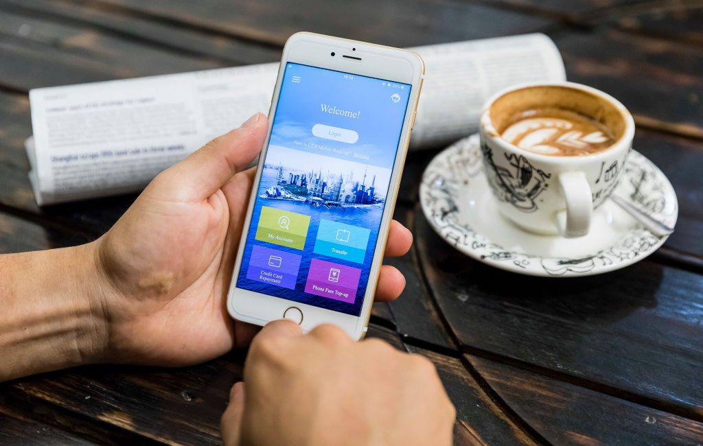 Banking app on mobile with coffee and the paper