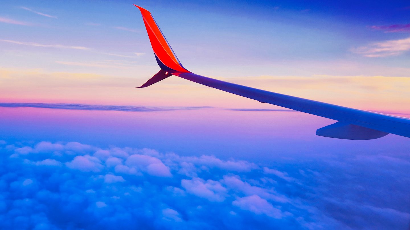 A plane wing over an aerial sunset.