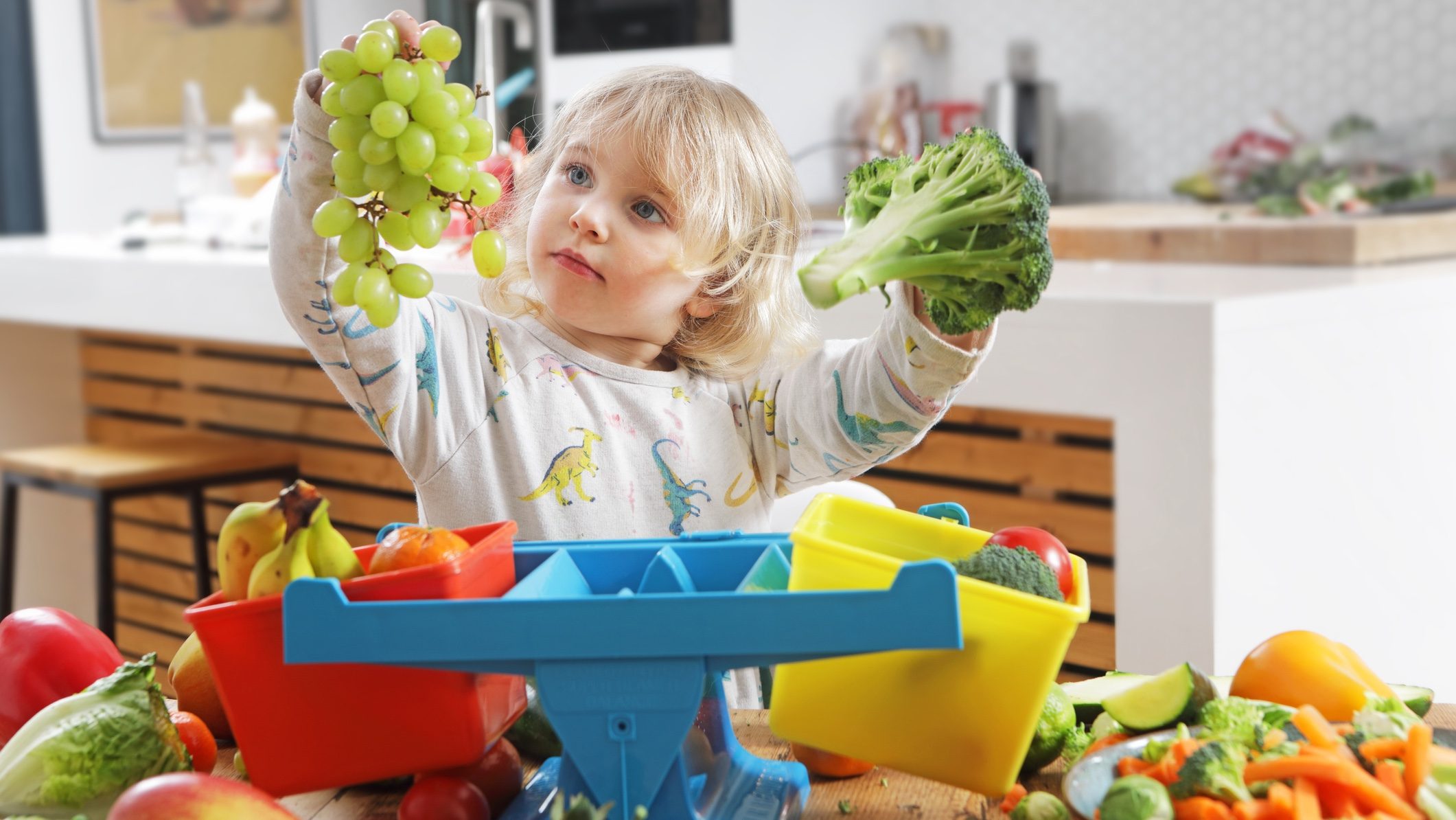 Child weighing fruit on scales to represent the meaning of loan to value ratio (LVR).