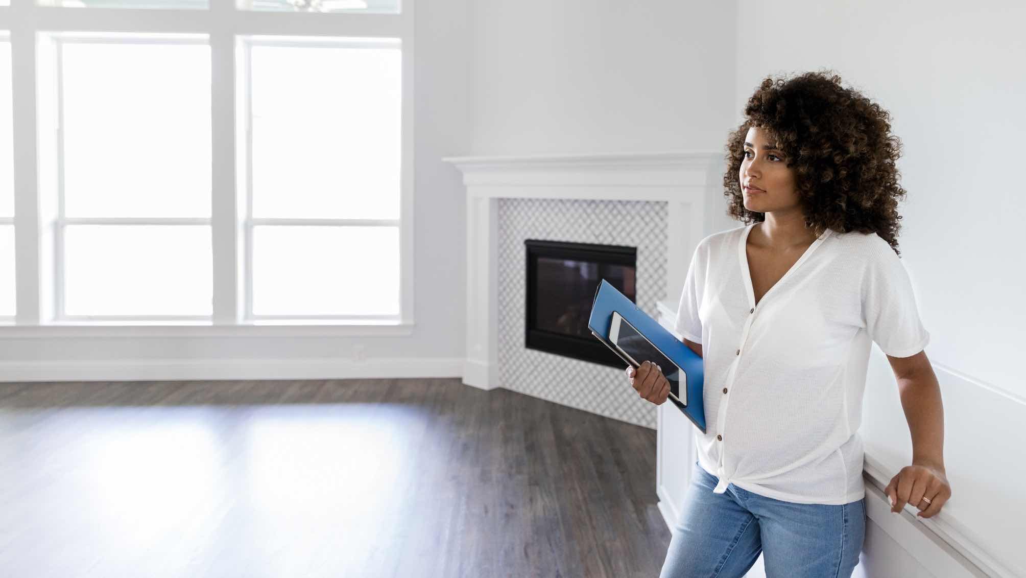 Woman inspecting home, considering her first home purchase.