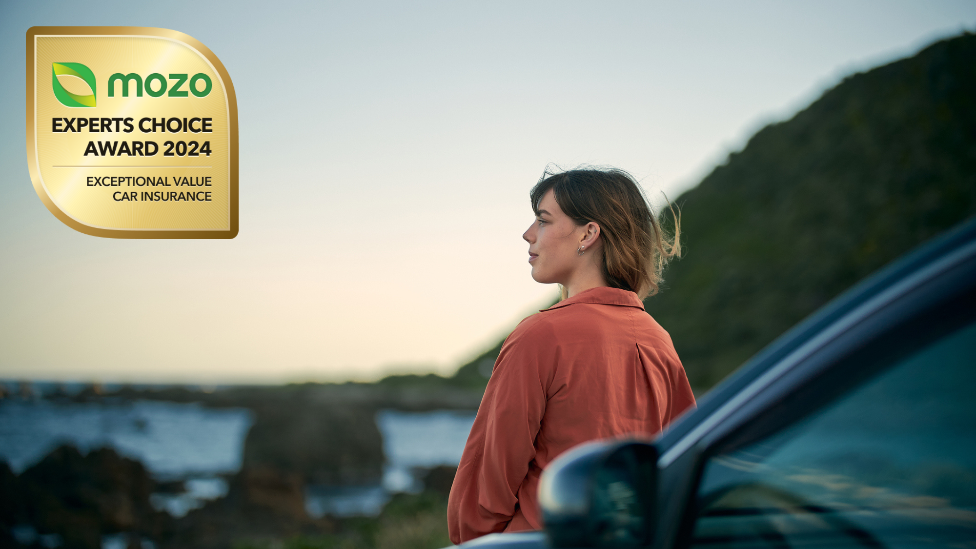 Woman leaning against her car looking into the distance. On top of the image, there's an awards badge that reads 'Mozo Experts Choice Award 2024, Exceptional Value Car Insurance'